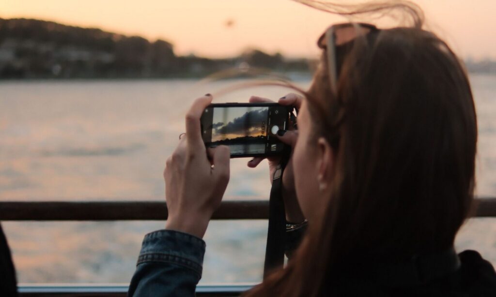 tjej fotar med mobilen